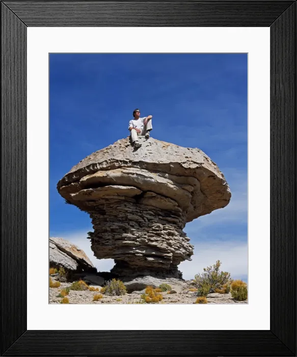 Framed Print : A tourist sits on top of a massive wind-eroded boulder Framed Print : A tourist sits on top of a massive wind-eroded boulder