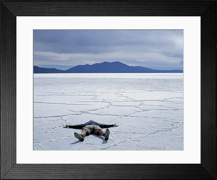 Framed Print : A tourist lies on the salt crust of the Salar de Uyuni