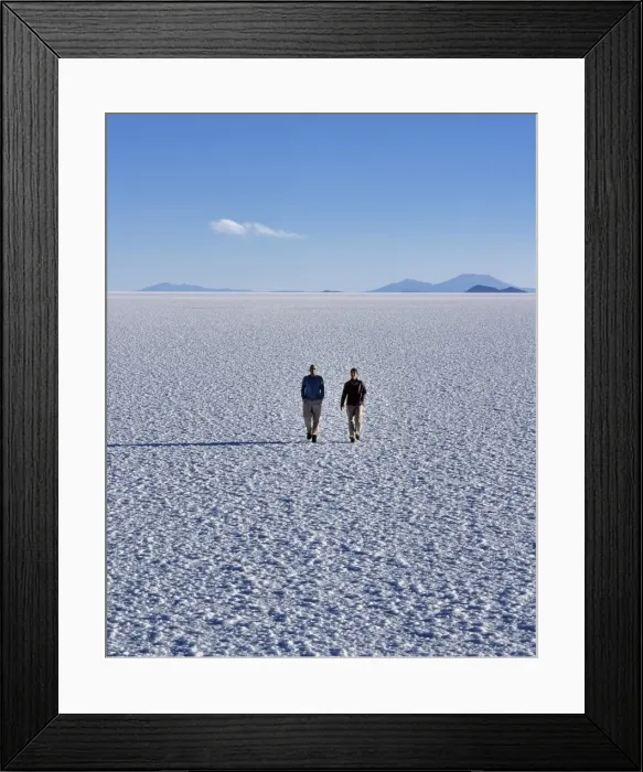 Framed Print : Two tourists walk across the endless salt crust of the Salar de Uyuni Framed Print : Two tourists walk across the endless salt crust of the Salar de Uyuni