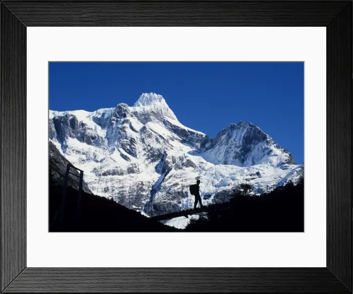 Framed Print : Trekker crosses bridge over Rio Frances with summit of Paine Grande behind (MR) Framed Print : Trekker crosses bridge over Rio Frances with summit of Paine Grande behind (MR)