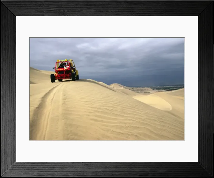 Framed Print : A dune buggy on the sand dunes bordering the city of Ica