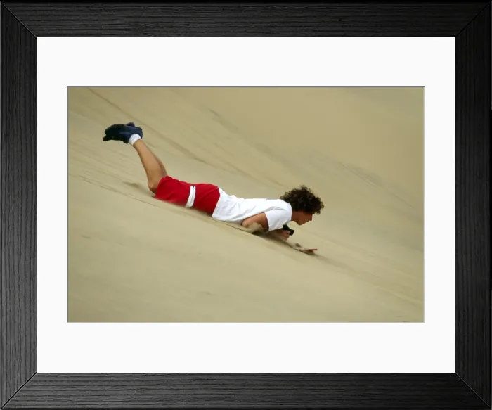 Framed Print : A sandboarder speeds down a dune head first Framed Print : A sandboarder speeds down a dune head first