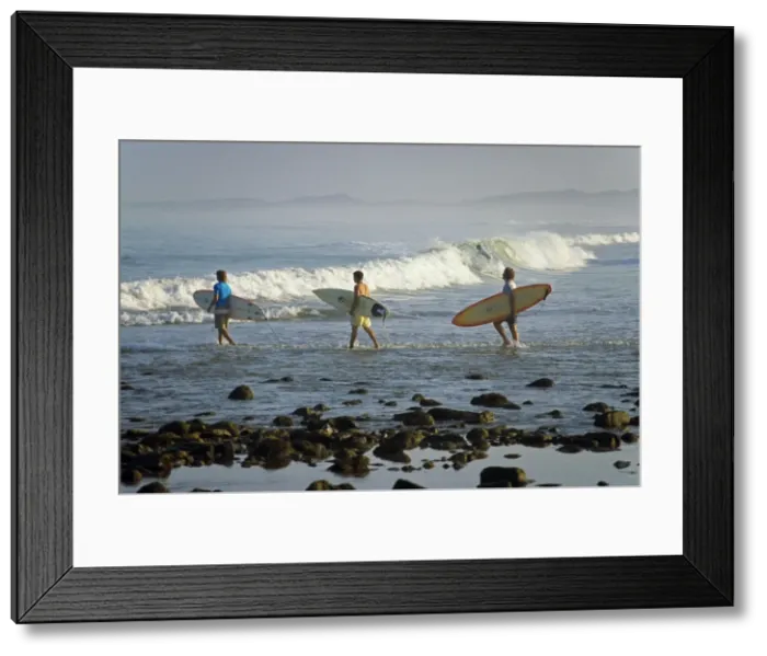 Framed Print : Surfers head into the surf at Mancora on the northern coast of Peru Framed Print : Surfers head into the surf at Mancora on the northern coast of Peru