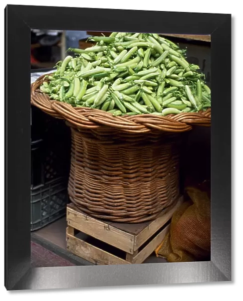 Fresh pea pods in a basket at Mercado dos