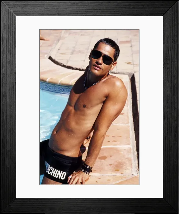 Framed Print : Man sitting on side of swimming pool with legs in water Framed Print : Man sitting on side of swimming pool with legs in water