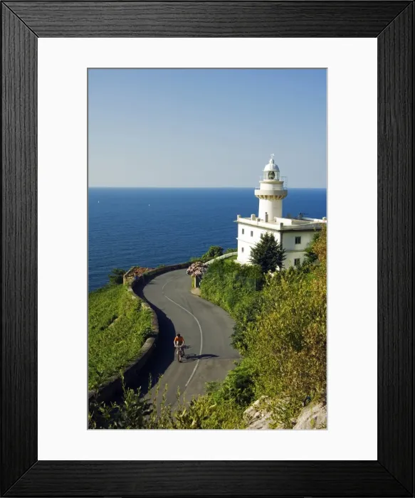 Framed Print : San Sebastian Bay Clifftop Lighthouse with Cyclist Riding uphill Framed Print : San Sebastian Bay Clifftop Lighthouse with Cyclist Riding uphill