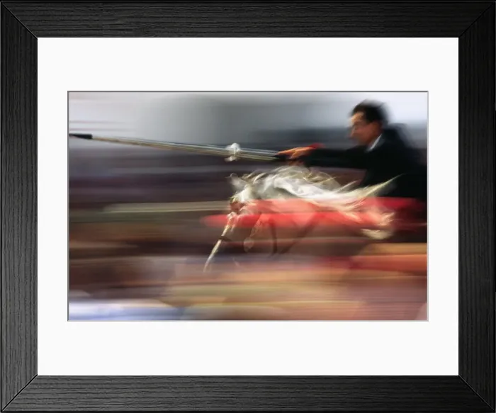 Framed Print : A rider on horseback speeds through the crowd attempting Framed Print : A rider on horseback speeds through the crowd attempting