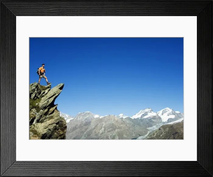 Framed Print : Hiker high on trail above snow capped mountains (MR) Framed Print : Hiker high on trail above snow capped mountains (MR)