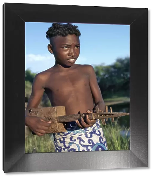 A young Malagasy boy playing a homemade guitar