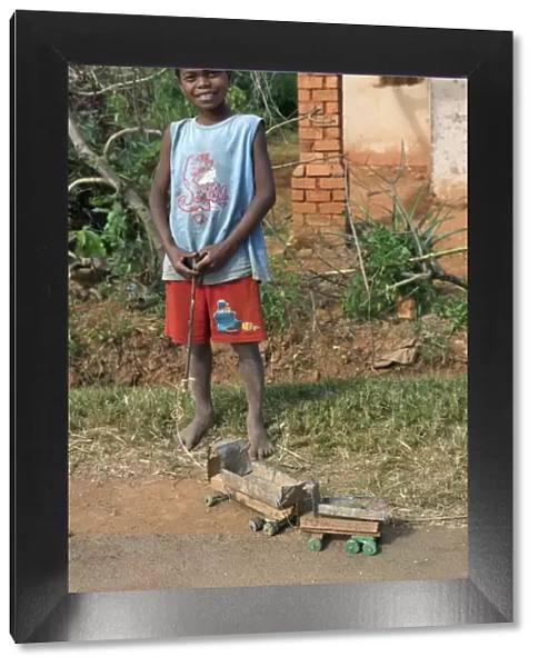 A young boy proudly displays his homemade toy truck