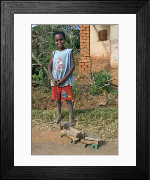 Framed Print : A young boy proudly displays his homemade toy truck Framed Print : A young boy proudly displays his homemade toy truck