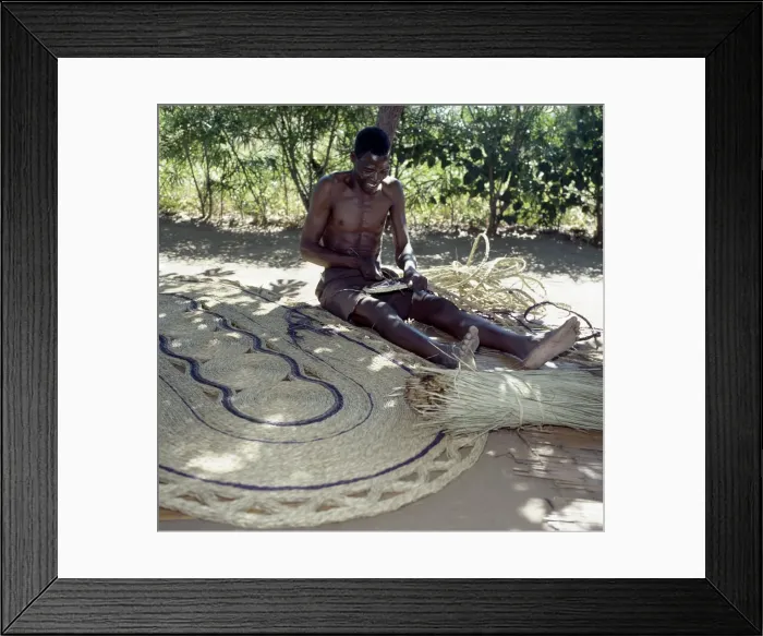 Framed Print : A man makes attractive floor mats from dried palm fronds near Liwonde