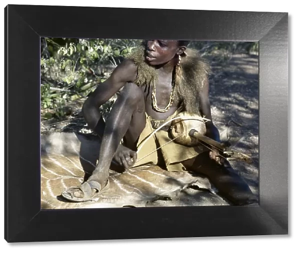 Hadza youth sings to the accompaniment of his two-stringed musical instrument