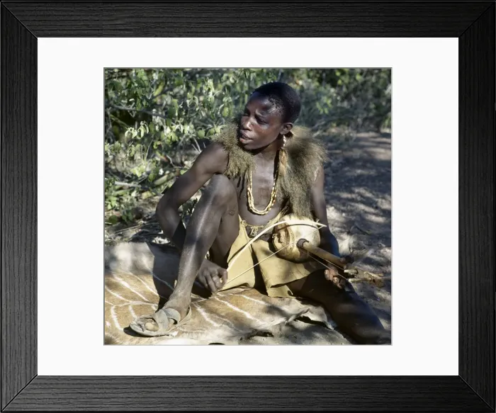 Framed Print : Hadza youth sings to the accompaniment of his two-stringed musical instrument Framed Print : Hadza youth sings to the accompaniment of his two-stringed musical instrument