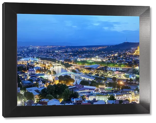 Tbilisi and the Mtkvari river at dusk. On the right the Holy Trinity Cathedral (Tsminda