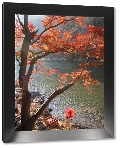 Arashiyama, Kyoto, Kyoto prefecture, Kansai region, Japan. Woman with red umbrella