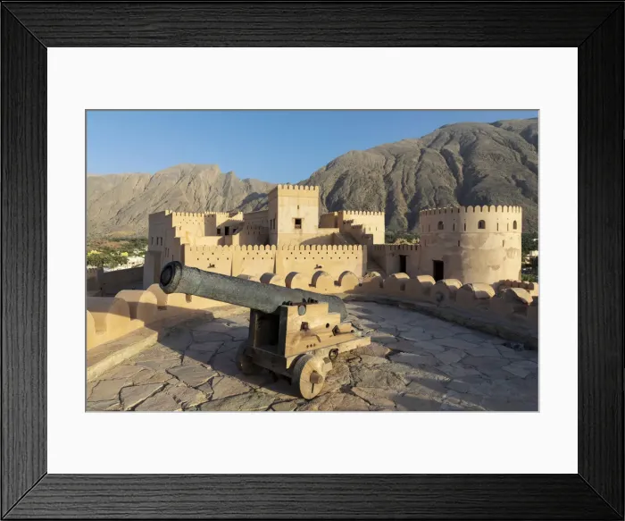 Framed Print : Oman, Al-Batinah Region, Nakhal, Nakhal Fort and cannon located at the foot of Jebel
