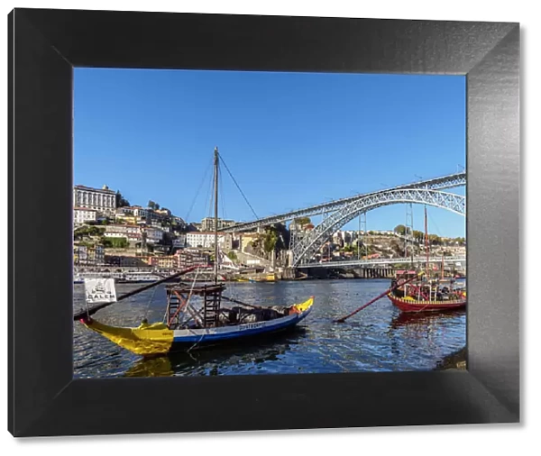 Traditional boats on Vila Nova de Gaia bank of Douro River, Dom Luis I Bridge in