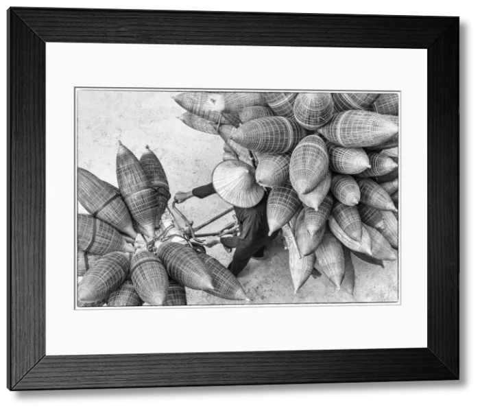Framed Print : A man on the bicycle loaded with the conical bamboo fish traps, near Hanoi, Vietnam