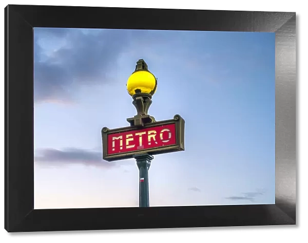 Illuminated Metro sign at sunrise, Paris, Ale-de-France, France