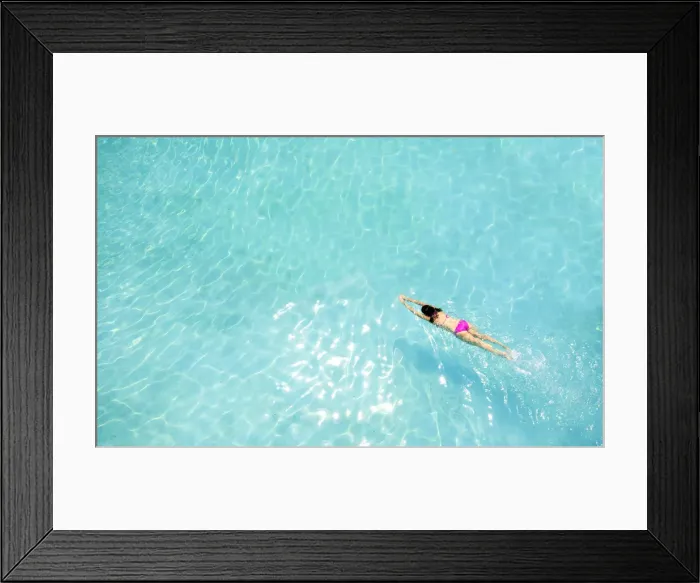Framed Print : Central America, Belize, Cayo, a girl in a pink bikini swimming in a blue swimming pool Framed Print : Central America, Belize, Cayo, a girl in a pink bikini swimming in a blue swimming pool