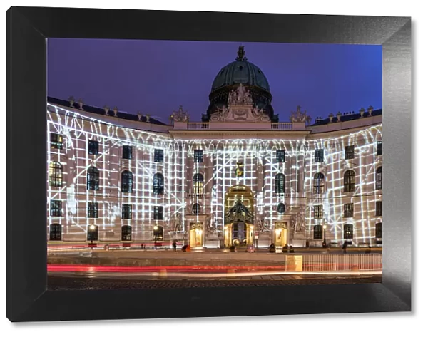 Night view of Michaelerplatz with lights show on the facade of Hofburg Palace, Vienna