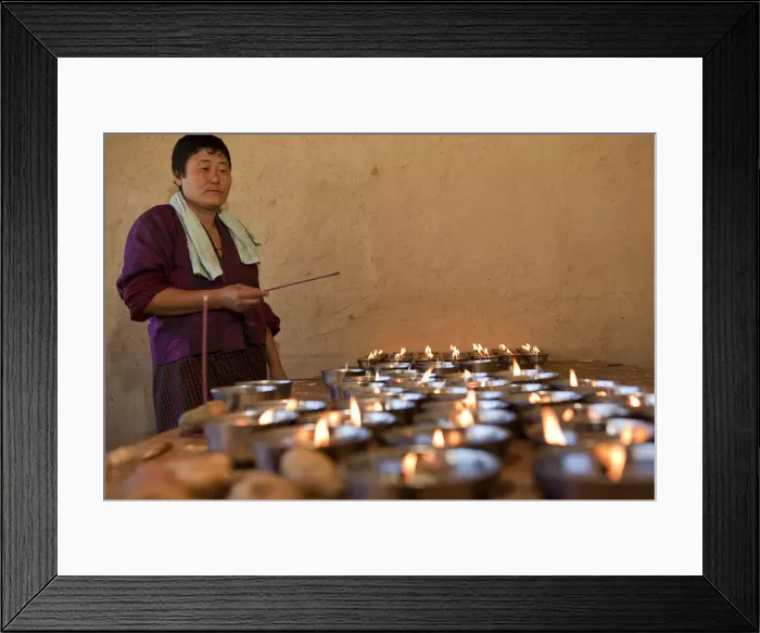 Framed Print : A woman lighting butter candles in Ura in the Bumthang Valley of Bhutan Framed Print : A woman lighting butter candles in Ura in the Bumthang Valley of Bhutan