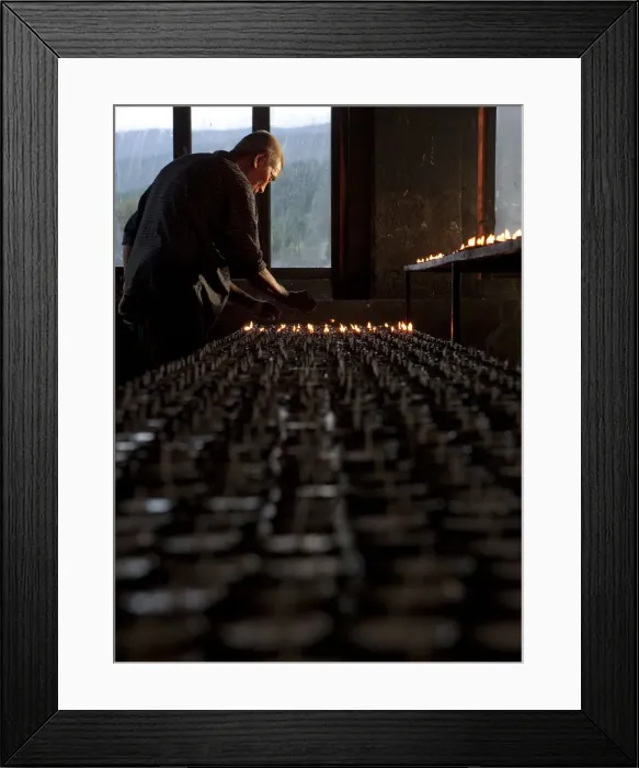 Framed Print : A man lighting candles in a temple in Bhutan Framed Print : A man lighting candles in a temple in Bhutan