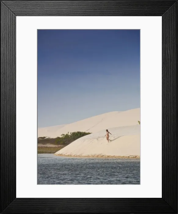 Framed Print : South America, Brazil, Maranhao, a woman in a bikini descends a dune in the Lagoa