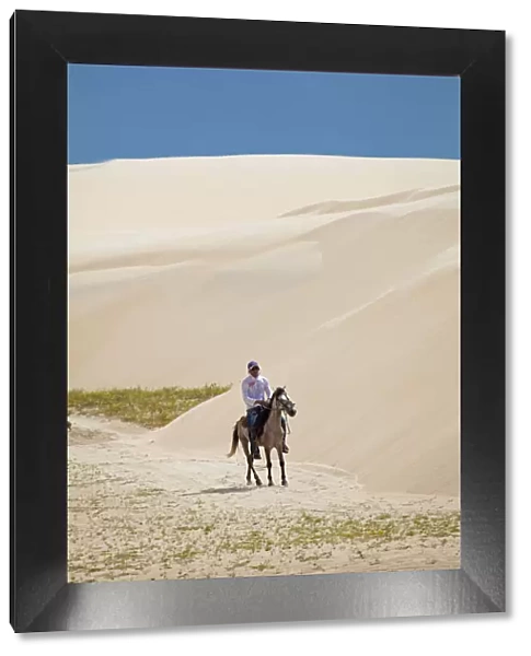 South America, Brazil, Maranhao, horseman riding through the sand dunes in the pequenos