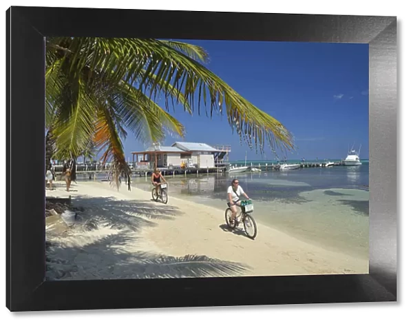 Tourists enjoying a bike ride along the beach at San Pedro, Ambergris Caye, Caribbean