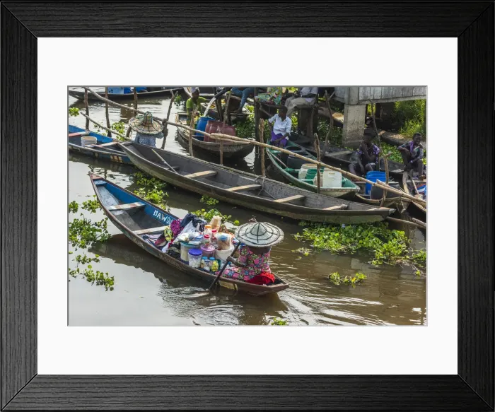 Framed Print : Africa, Benin, Lake Nokoua. A woman drives her canoe to the market in the famous Framed Print : Africa, Benin, Lake Nokoua. A woman drives her canoe to the market in the famous
