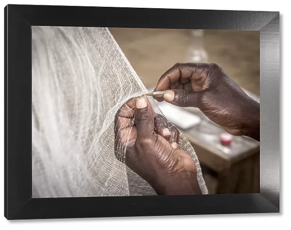 Africa, Benin, Grand Popo. Man repairing his fishing net. Detail