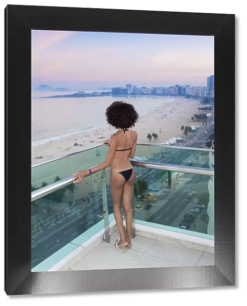 South America, Brazil, Rio de Janeiro, a model in a black bikini stands over Copacabana