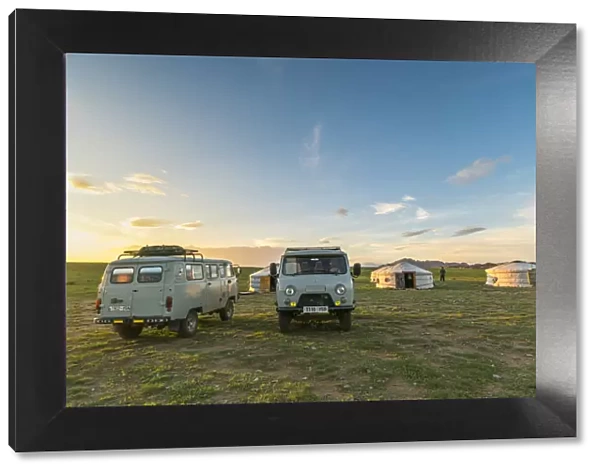 Mongolian nomadic traditional gers and soviet minivans at sunset. Middle Gobi province