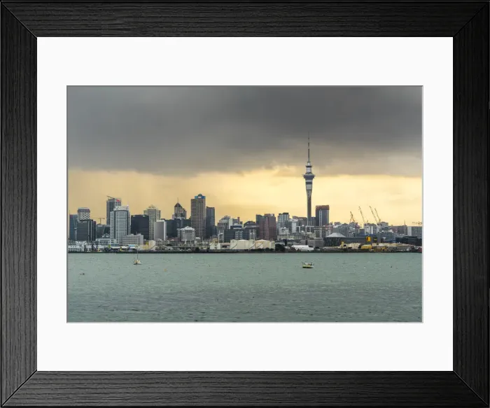 Framed Print : Skyline of Auckland Central Business District under a gloomy sky at sunrise. Auckland City, Auckland region Framed Print : Skyline of Auckland Central Business District under a gloomy sky at sunrise. Auckland City, Auckland region