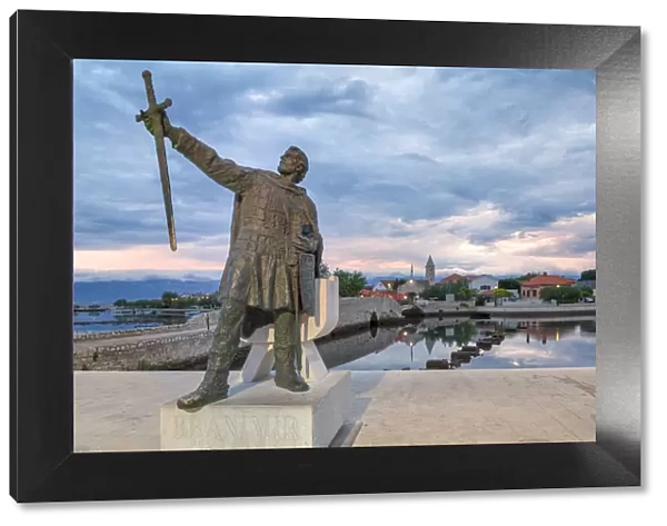 monument of Branimir of Croatia in Nin, on the background the old bridge that connects