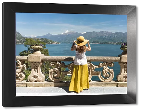 Tourist admiring Como lake view from the balcony of villa del Balbianello on punta