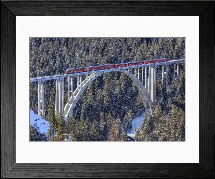 Framed Print : Red train of Rhaetian Railway on Langwies Viaduct surrounded by snowy woods Canton Framed Print : Red train of Rhaetian Railway on Langwies Viaduct surrounded by snowy woods Canton