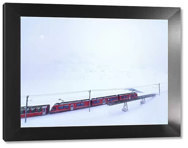 Bernina Express train at Bernina Pass during a snowstorm, canton of GraubAonden, Engadin
