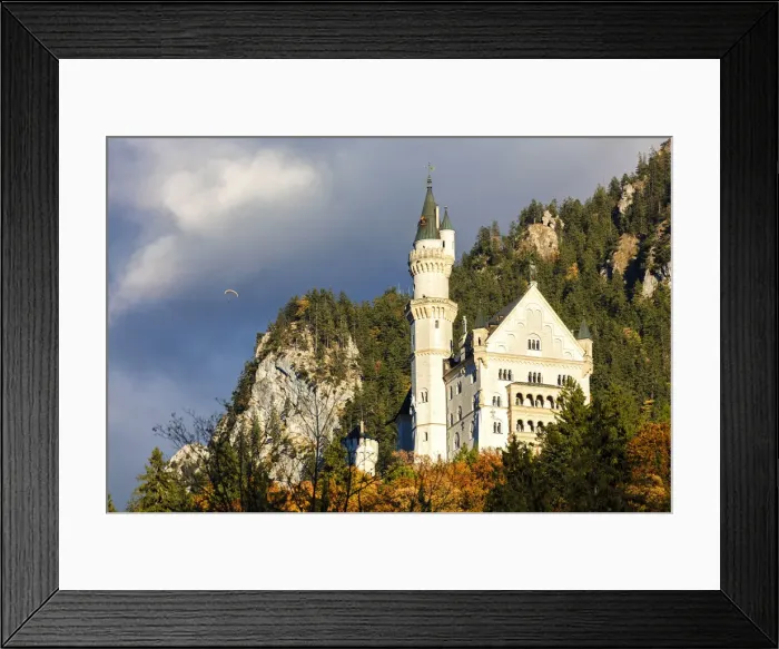 Framed Print : Neuschwanstein Castle framed by paraglide in the cloudy sky and the colorful woods Framed Print : Neuschwanstein Castle framed by paraglide in the cloudy sky and the colorful woods