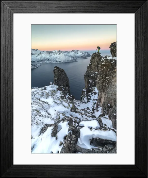 Framed Print : Photographer on the rocks on top of Mount Hesten admires the Mefjorden and the frozen Framed Print : Photographer on the rocks on top of Mount Hesten admires the Mefjorden and the frozen