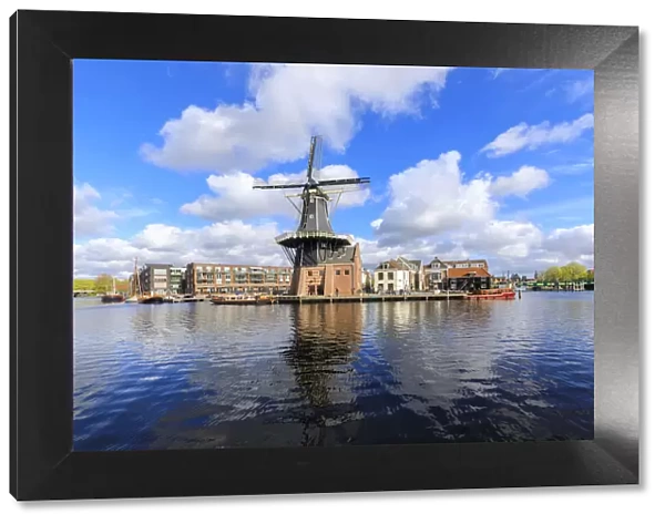View of Windmill De Adriaan reflected in the canal of the river Spaarne Haarlem North