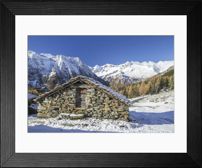 Framed Print : A mountain hut surrounded by snow capped peaks and colorful woods in autumn at Alp Entova Framed Print : A mountain hut surrounded by snow capped peaks and colorful woods in autumn at Alp Entova