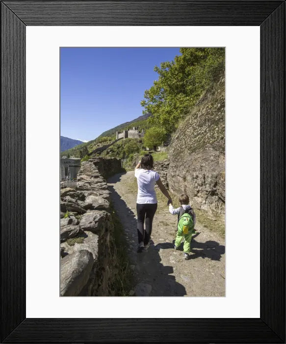 Framed Print : Mother accompanies her son down the path that leads to Castle Visconti Venosta. Grosio