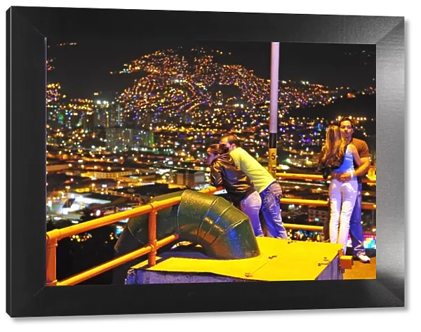 Couples viewing Medellin at night, Colombia, South America