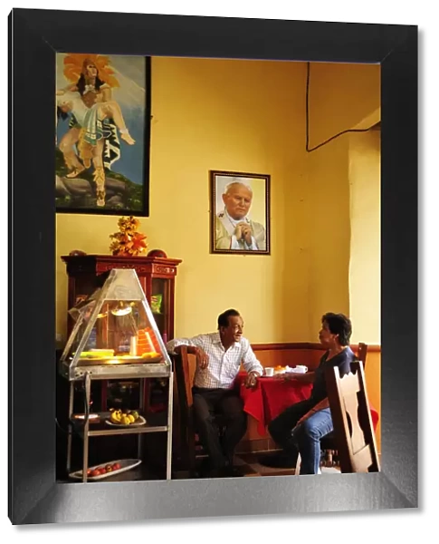 Two men talking in a cafe in Santa Fe de Antioquia, Colombia, South America