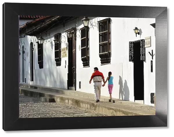 Father and daughter walking in the Colonial town of Giron, Colombia, South America