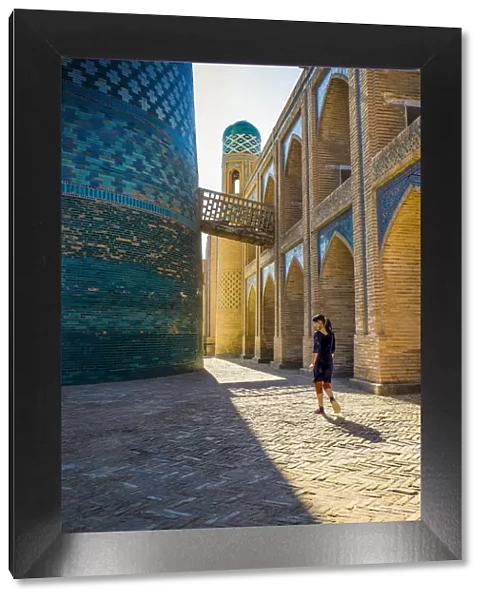 Kalta Minor minaret, Khiva. Uzbekistan, Central Asia. Woman walking near the minaret