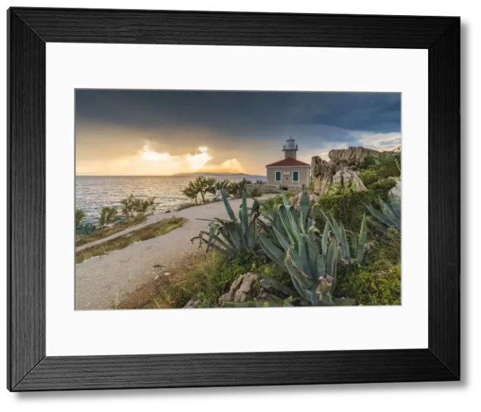 Framed Print : The sun is setting down behind St Peter lighthouse, in summer Framed Print : The sun is setting down behind St Peter lighthouse, in summer